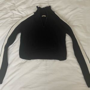 John Galt black quarter zip with white lines on the sleeves